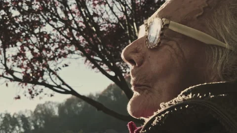 Face of an elderly woman with dementia and paralysis in the sunset. Stock Footage 164906053