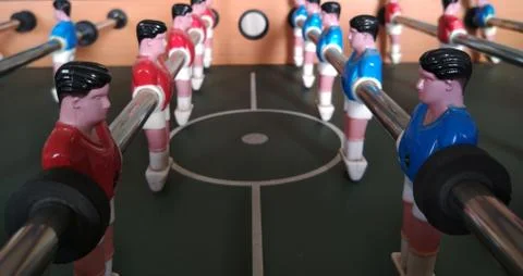 Face to face image of two teams in foosball table game. Stock Photos