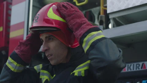Face of a firefighter in front of the truck putting his helmet on Stock Footage 283140383