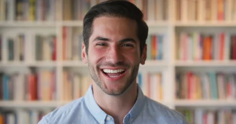 Face, friendly and funny with man in library as college or university professor Stock Footage 336643868