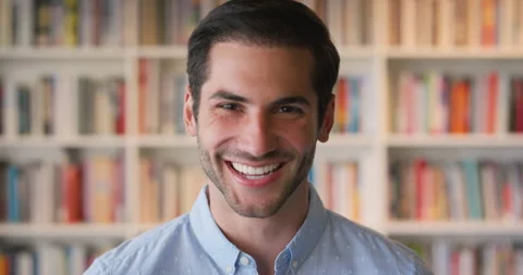Face, friendly and laughing with man in library as college or university Stock Footage 336643831