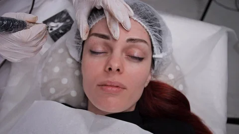 The face of a girl who does permanent eyebrow makeup. 4K Slow Mo Stock Footage 106896045