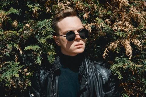 The face of the guy with glasses on the background of bushes Foto stock