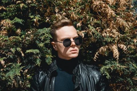 The face of the guy with glasses on the background of bushes Stock Photos