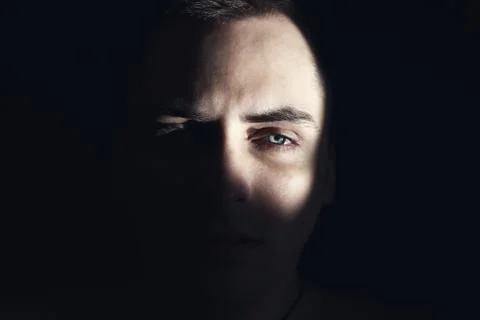 The face of the guy is half illuminated by the sun. Stock Photos