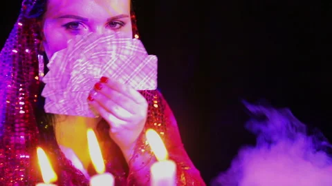 The face of a gypsy hiding behind the cards. Close-up Stock Footage 101115772