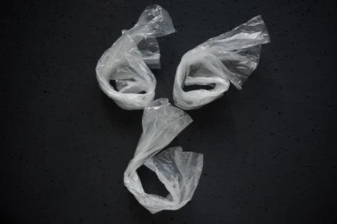 Face laid out of empty plastic bags on a dark background. Stock Photos