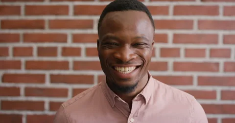 Face, laugh and black man on brick wall, business and career development with Stock Footage 336644440