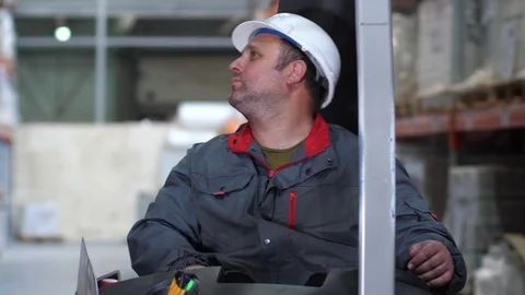 The face of a logistic warehouse worker. A man rides on a specialized technique Stock Footage 111768402
