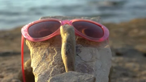 A face made from small rocks and pebbles with sunglasses and eyes Stock Footage 159061908