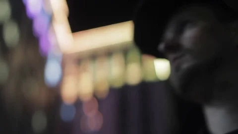 Face of a man against the background of a glowing building close-up Stock Footage 77332194