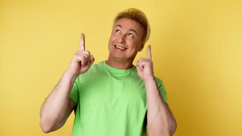 Face, man and pointing to mockup, advertising, branding in studio isolated on ye Video stock 242112880