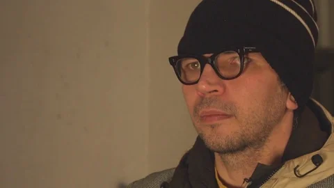 Face of a man close-up against a wall background. Video stock 73901603