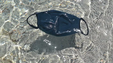 Face mask floating on crystal clear water in tropical sea Stock Footage 132000981