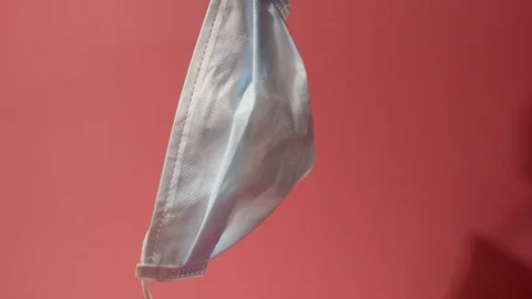 Face Mask hanging in pink background 스톡 동영상 124696439
