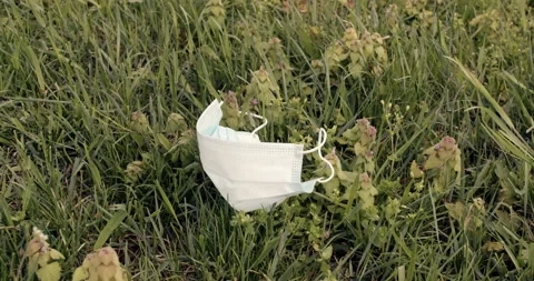 A face mask for protection, thrown down on the grass. Video stock 132165125