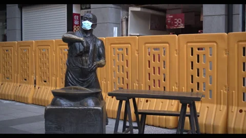 Face mask on statue  of man making noodles, Wuhan coronavirus lockdown, China Stock Footage 132610018