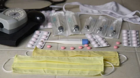 The face mask is on the table with pills, a thermometer and syringes. Stock Footage 143594853