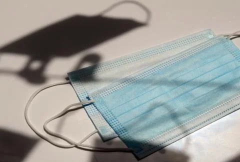 Face mask on the table with shadow under the sunlight Stock Photos
