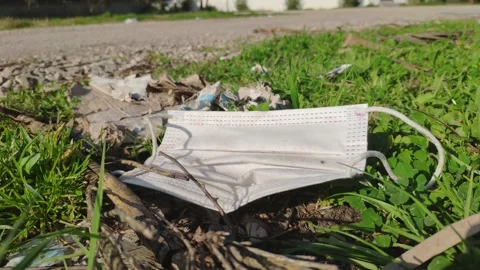 Face mask thrown on the side of the road Stock Footage 149387523