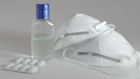 Face masks, hand sanitiser bottle and medicine packet Stock Footage 130957545