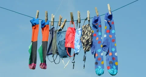 Face masks (re-usable) and socks drip drying on a washing line. Vídeo Stock 139301793