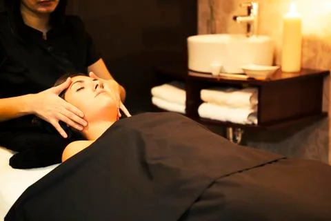 Face massage during spa session with candle lightning. Stock Photos