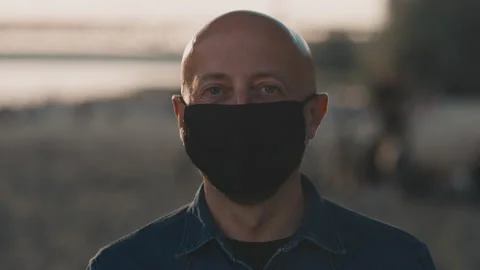 Face of mid-forties bald man on the beach during the amazing sunset who is Stock Footage 141677018
