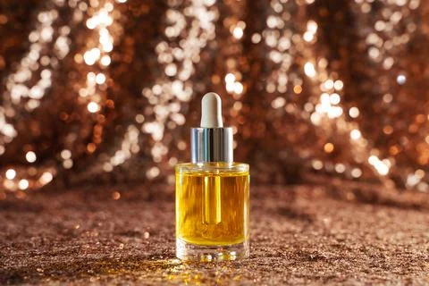 Face oil on sequin background Stock Photos