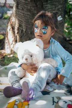Face Painting Little Girl Butterfly holding a teddy bear Stock Photos