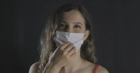 Face portrait of smiling young long haired girl is using face mask for protec Stock Footage 139824768