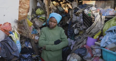 Face of poverty.  Poor Black African woman sitting in-front of her house which Stock Footage 139690437