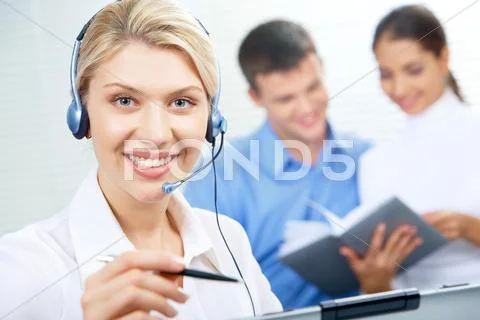 Face of pretty secretary wearing headset in working environment Stock Photos