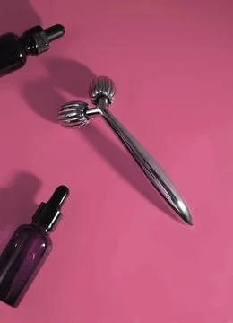 Face roller and bottle of serum Stock Photos