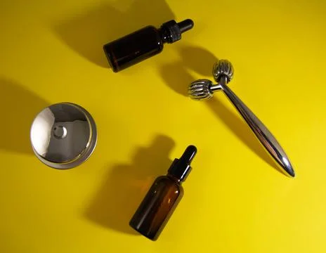 Face roller, jar of cream and bottle of serum Stock Photos