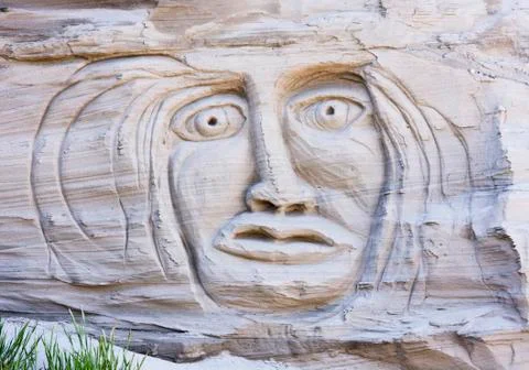 Face in a sand cliff Stock Photos