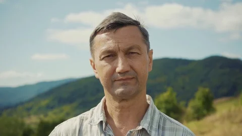 Face serious man look at camera background mountains summer elderly portrait Stock Footage 116997706
