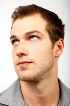 Face of serious man looking up Stock Photos