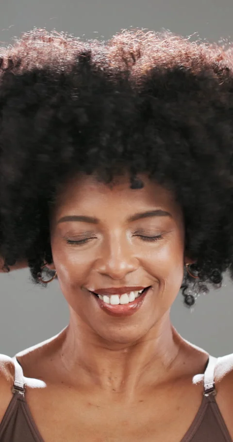 Face, shake and afro with black woman in studio for curl pattern, natural Stock Footage 311644079