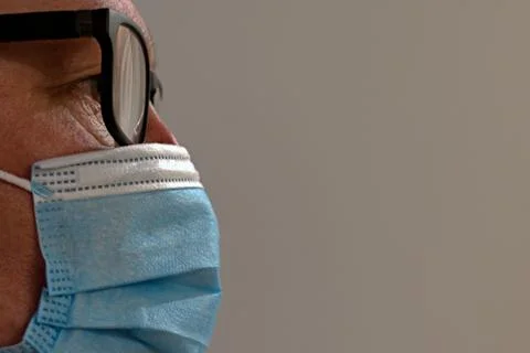 Face side of middle aged man in glasses and antivirus medical mask Stock Photos