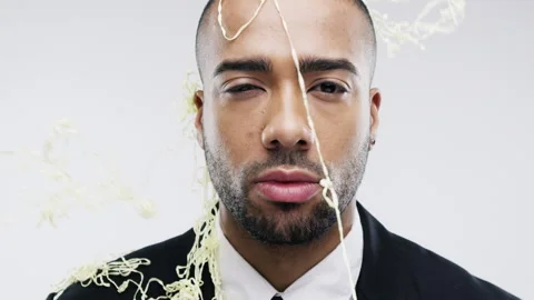 Face, silly string and groom with a man in studio on a gray background for his Stock Footage 222922328