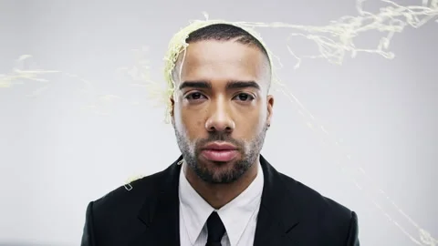 Face, silly string with bored groom on wedding day in studio and white white Stock Footage 262717701