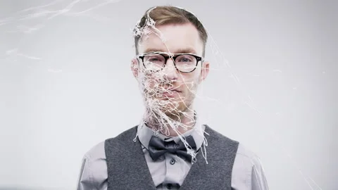 Face, silly string with bored man at event in studio and white background for Stock Footage 262840592