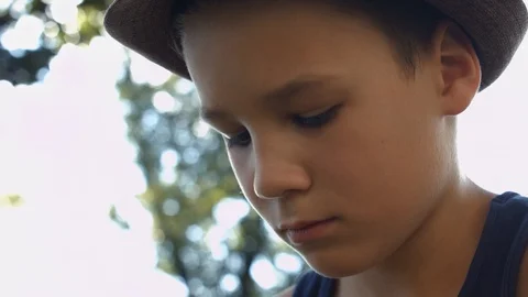 Face Smart Boy. Boy focused on solving Rubik's Cube in the park Stock Footage 116047569