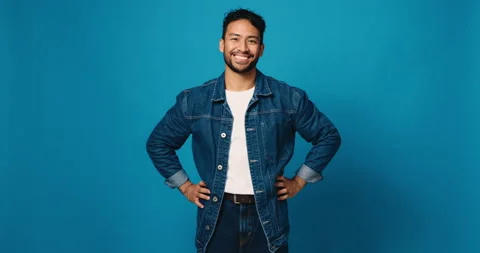 Face, smile and confident man in studio for fashion, denim jacket or blue Stock Footage 314370523