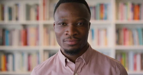 Face, smile and thinking with black man in library as college or university Video stock 336643793