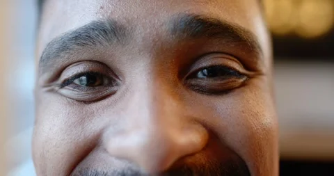 Face is smiling and blinking into camera at cafe booth as eye contact is Stock Footage 344963979