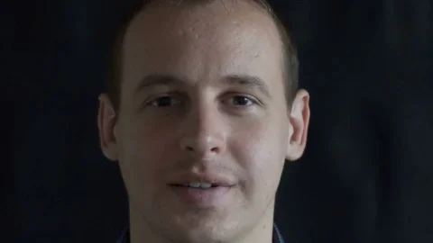 Face of a smiling man, a distorted random characters. Concept: a glitch in the Stock Footage 76564114