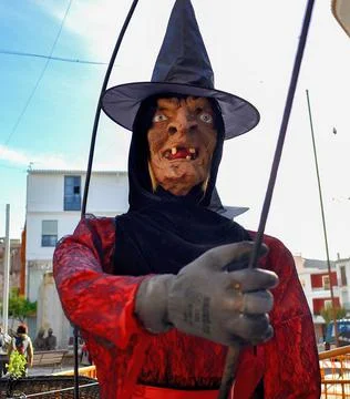 Face of a toothless witch doll dressed in red with witch hat Foto stock