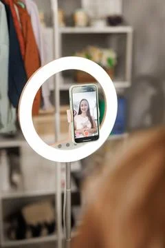 Face young female influencer working online creating content for social media Stock Photos